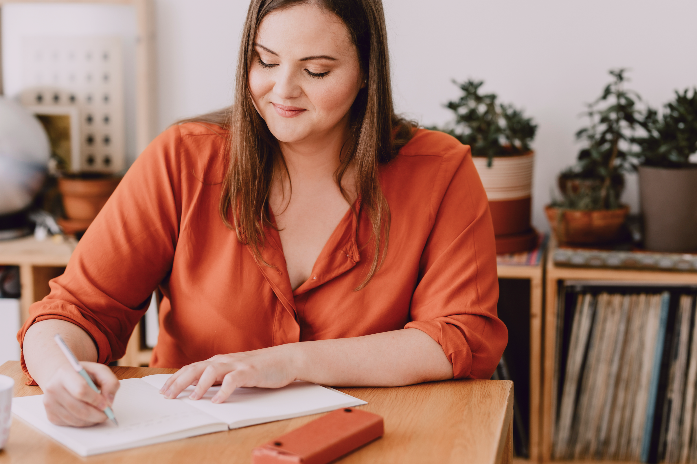 woman with long hair writing in her book