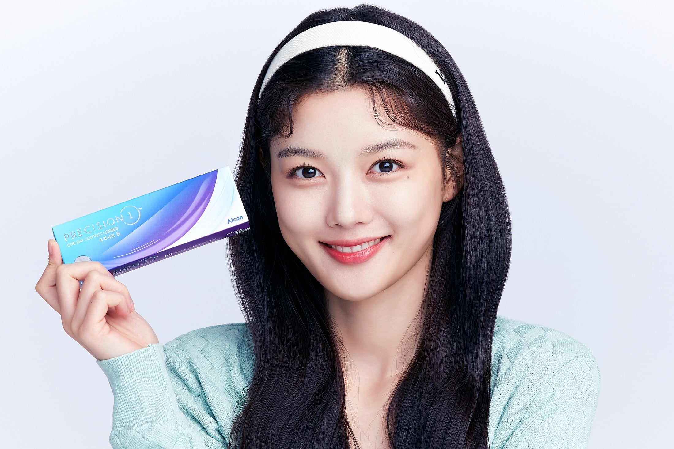 프리시전 원 렌즈를 손에 들고 환하게 웃고 있는 김유정