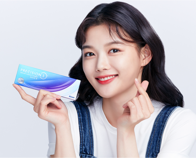 프리시전 원을 들고 손가락 하트를 하는 김유정
